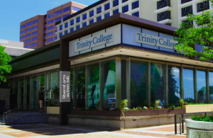 Trinity's 10 Constitution Plaza building in downtown Hartford. This one-story, glass building is above street level surrounded by other downtown businesses.