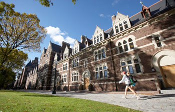 Student walks down "The Long Walk" at Trinity on a sunny day