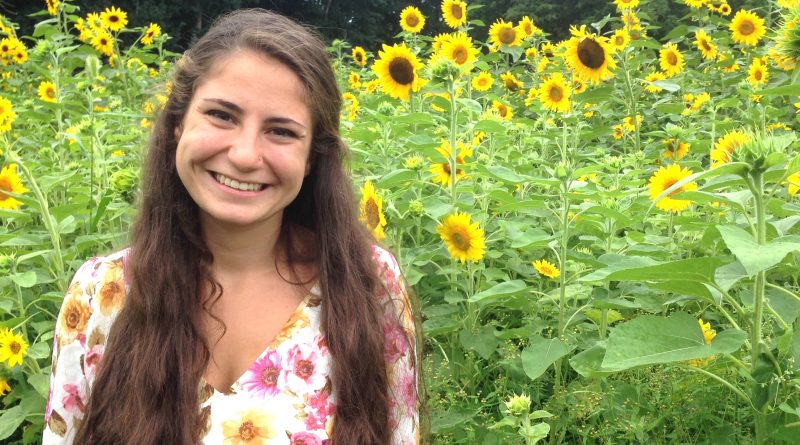 Vianna Iorio ('19)' stands in a field of flowers.