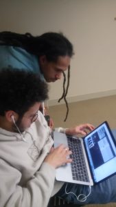 Khaiim Kelly instructs Cody Maldonado on how to use beat making software. 