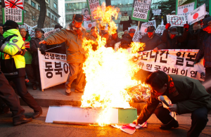  South Koreans burn a Japanese flag and effigy of Prime Minister Abe in front of the Japanese Embassy in Seoul on 27 December, 2013 after Abe visited the controversial shrine. http://www.ibtimes.co.uk/japan-pm-shinzo-abe-sends-offering-yasukuni-shrine-angering-china-south-korea-1470538 -This image shows how a simple act of honoring a notorious dead victim can still enrage the people today, indicating the political influence dead victims can still hold through their commemoration.   