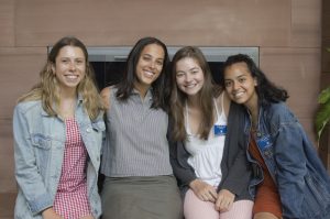 Three students pose for a picture alongside a Trin admissions counselor before a summer tour of campus.