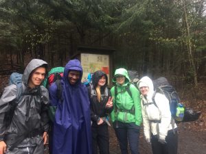 Students in ponchos out on a trail for Quest training