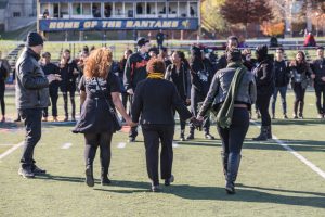 President Joanne Berger-Sweeney, center, and two students walk hand in hand at a demonstration of solidarity at Homecoming 2015.