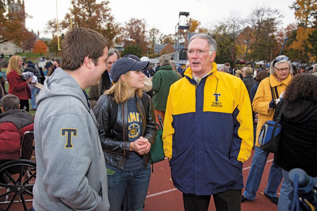 Jones speaks with Elizabeth Gerber ’14 and Benjamin Rudy ’13 during the 2013 Homecoming football game. Jones’s wife, Jan, is at right.